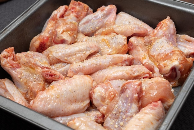 Raw chicken wings in a bowl unprepared with spices