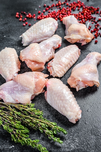 Raw chicken wings, organic poultry meat. Black background. 