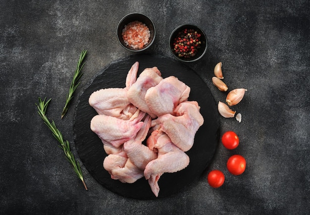 Raw chicken wings Poultry meat with spices salt and pepper on gray background