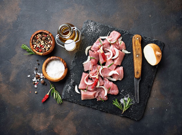 Raw chopped meat with spices on rusty background