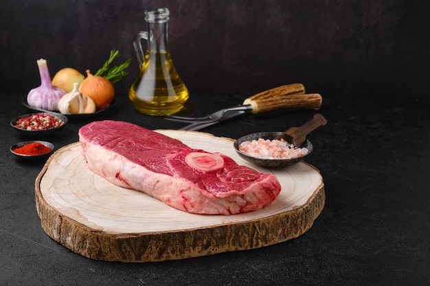 Photo raw chuck eye steak on wooden cutting board ready for cooking