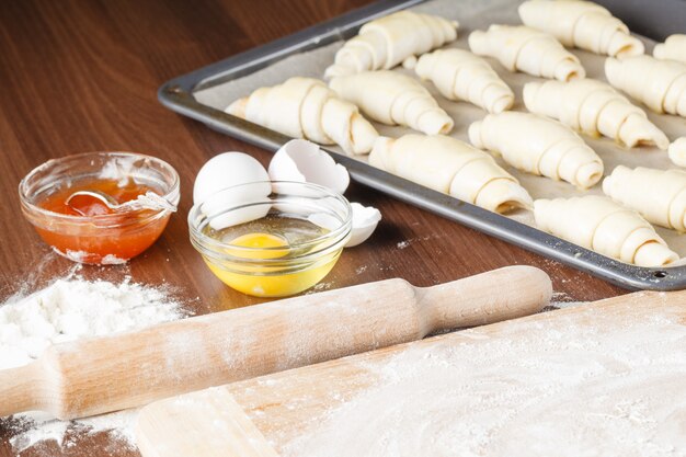 Raw croissants on parchment preparation process