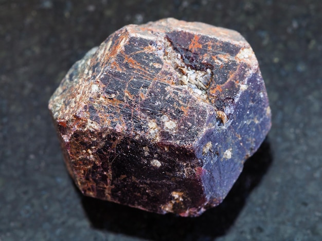 Raw crystal of dravite tourmaline gemstone on dark