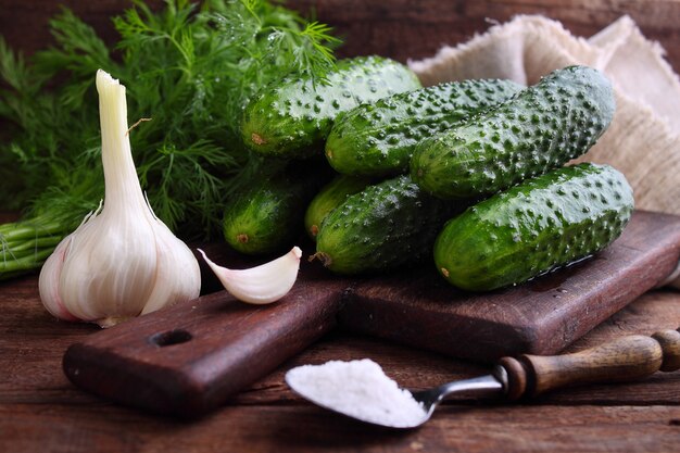 Raw cucumbers for pickling on a wooden background