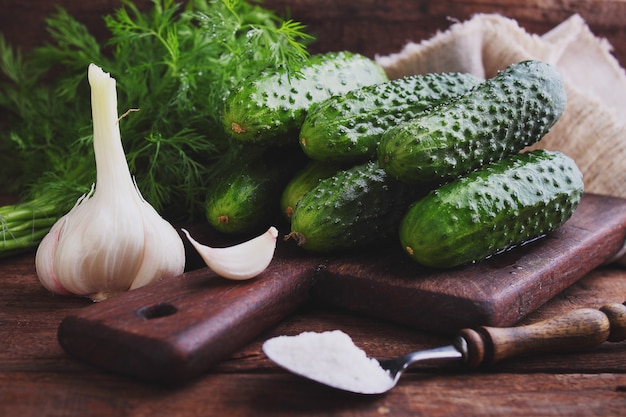 Raw cucumbers for pickling on a wooden background