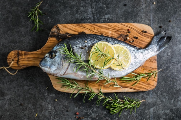 Raw dorado fish with spices Dorado and ingredients for cooking on a table