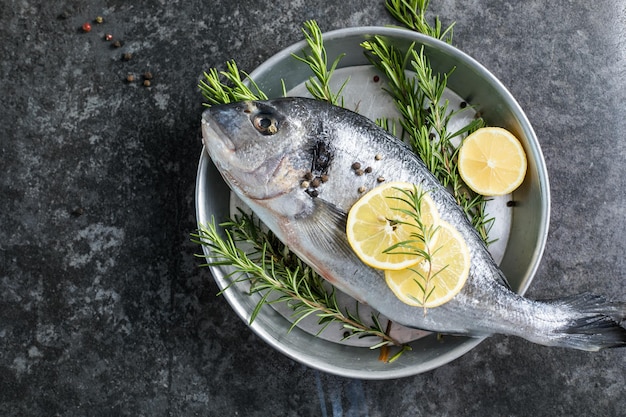 Raw dorado fish with spices Dorado and ingredients for cooking on a table