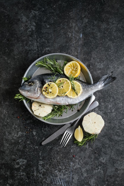 Raw dorado fish with spices Dorado and ingredients for cooking on a table