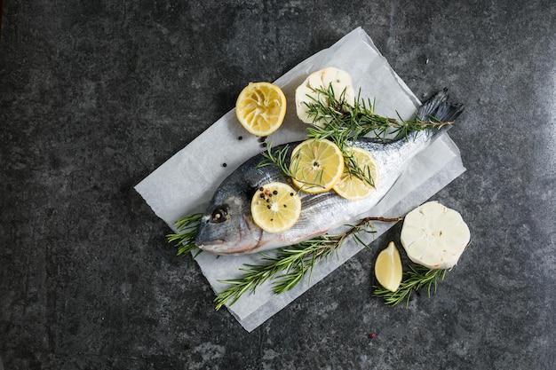 Raw dorado fish with spices Dorado and ingredients for cooking on a table