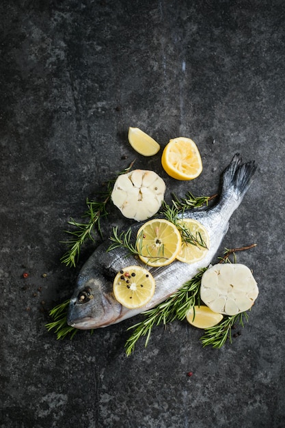 Raw dorado fish with spices Dorado and ingredients for cooking on a table