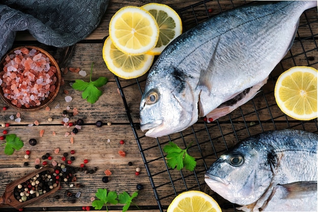 Raw dorado with spices ready to cook on a wooden background