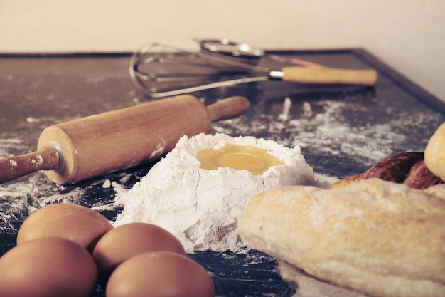 Photo raw dough for bread with ingredients on black background