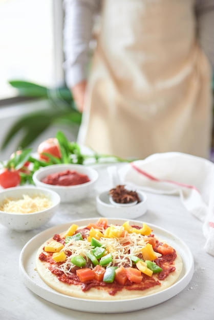 Raw dough for pizza preparation with ingredient tomato sauce mozzarella