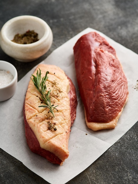 Raw duck breast fillet for cooking on the white paper