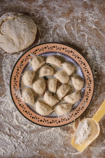 Raw dumplings are laid out on a plate top view