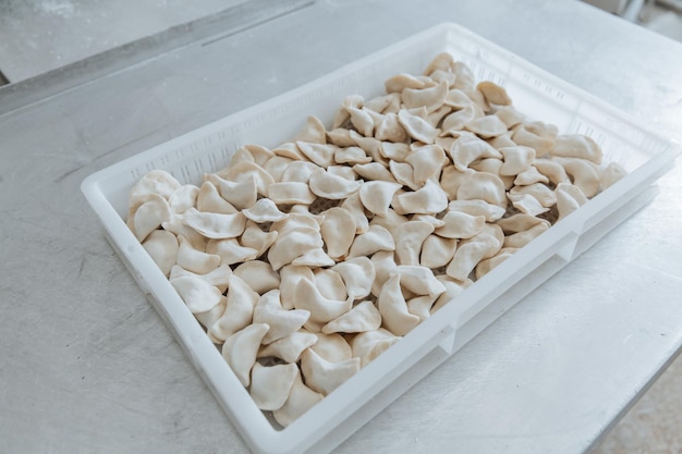 Raw dumplings from the dough in handmade flour lie in a white box