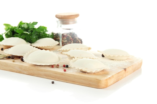 Raw dumplings and ingredients on wooden desk isolated on white