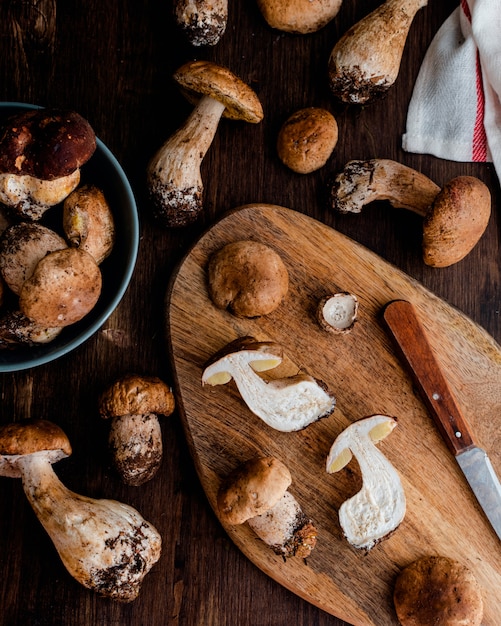 Raw edible penny bun porcini mushrooms on rustic dark wooden table