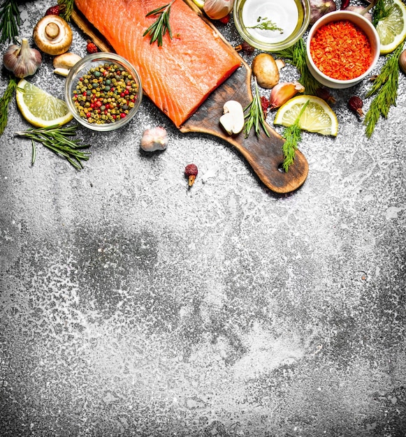 Raw fish. Fresh salmon fillet with herbs and spices on rustic table.