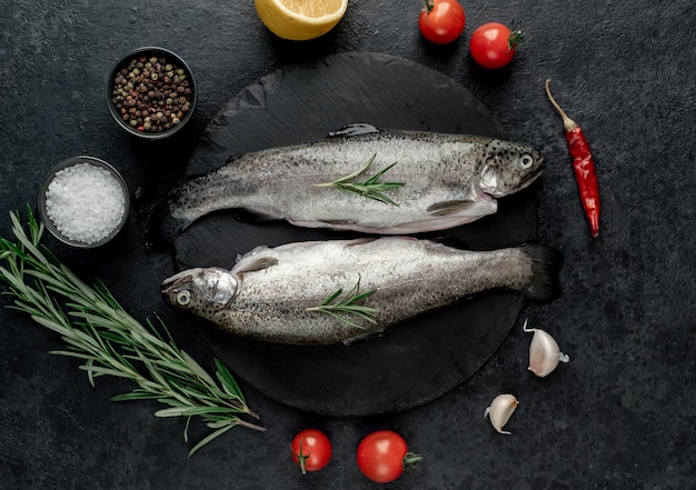 raw fish trout with spices ready for cooking on a stone background