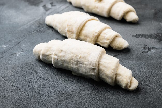 Raw fresh croissants  set, on gray stone table background