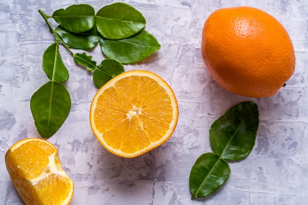 Raw fresh orange fruit and green leaves.