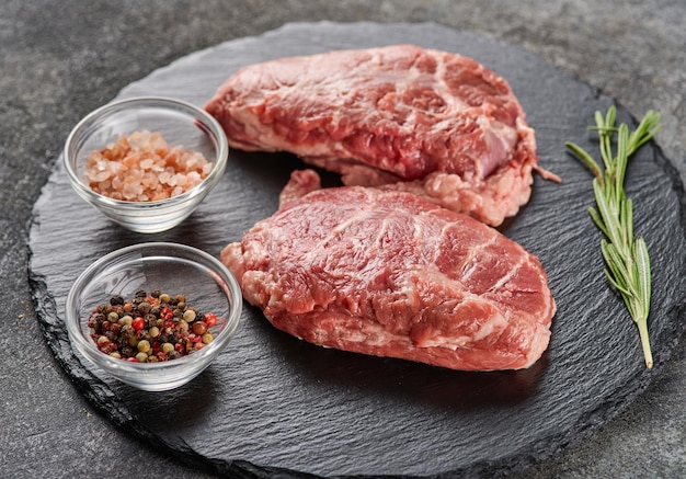 Raw fresh pork cheeks with salt and pepper Preparing Meat for Dinner