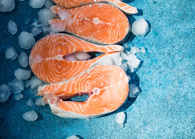 Raw, fresh salmon steak on blue concrete. Raw salmon red fish. Cooking salmon, seafood. Healthy food concept. Salmon and spices