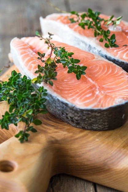 Raw, fresh salmon steak on a  board and spices around. Raw salmon red fish. Cooking salmon, seafood. Healthy food concept. Salmon and spices