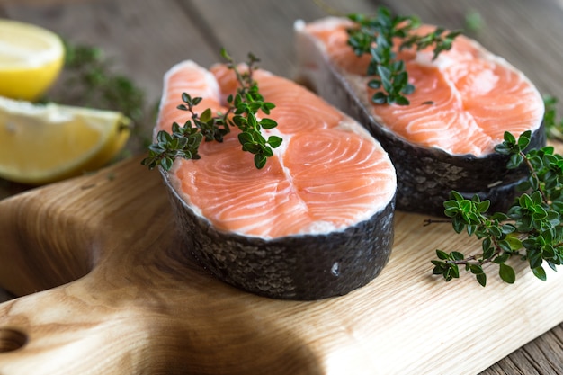 Raw, fresh salmon steak on a  board and spices around. Raw salmon red fish. Cooking salmon, seafood. Healthy food concept. Salmon and spices