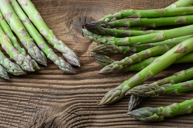 Raw garden asparagus stems Fresh green spring vegetables on wooden background Asparagus officinalis