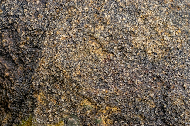 Raw gray granite rock texture background Fragment of natural stone wall