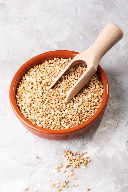 Raw green buckwheat in a brown clay bowl