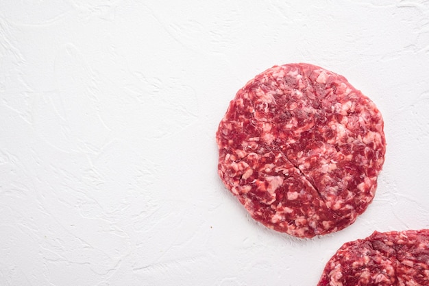 Raw Ground beef meat Burger steak cutlets on white stone background top view flat lay with copy space for text