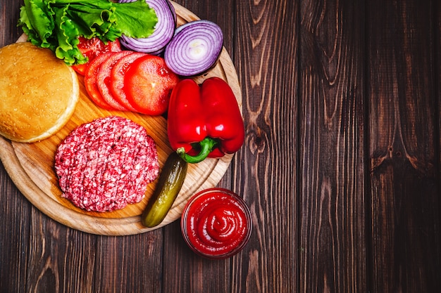 Raw Ground beef meat Burger steak cutlets with seasoning, cheese