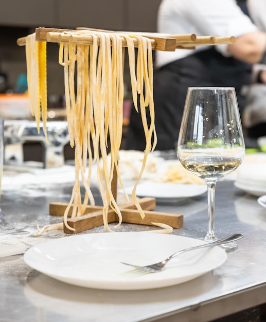 Raw homemade pasta on wooden cutting board. Uncooked fresh pasta.