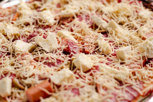 Raw homemade pizza closeup Pizza background with mozzarella cheese and salami