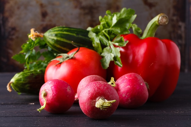 Raw ingredients - cauliflower, potato, zucchini, carrot, onion, pepper, cooking roasted vegetables. On a dark wooden surface