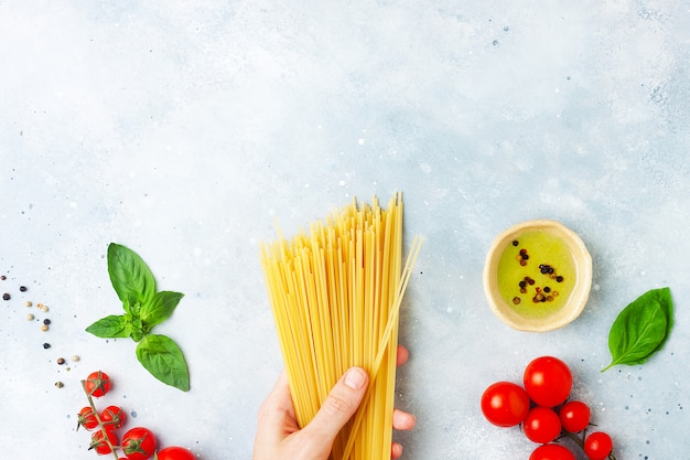 Raw ingredients for cooking pasta on grey stone background