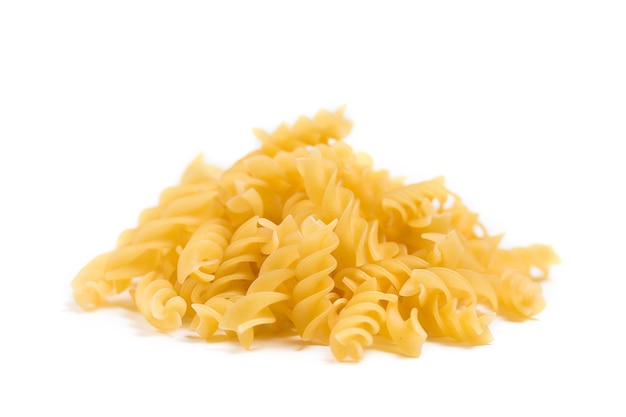 Raw Italian pasta in a heap on the table isolated on white background.