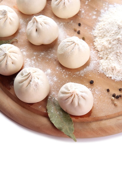 Raw khinkali on wooden desk isolated on white