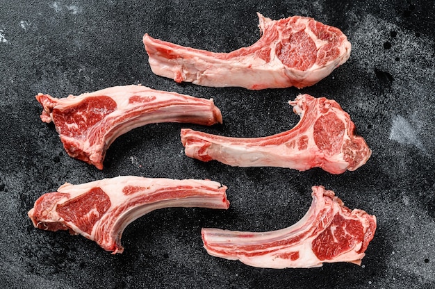 Raw lamb chops on black slate