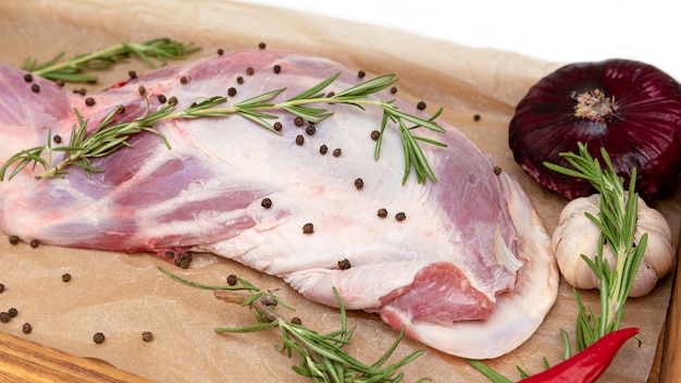 Raw lamb leg ready for cooking with garlic and rosemary