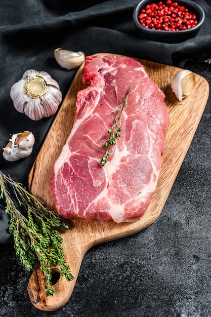 Raw marble pork steak on a wooden chopping Board.