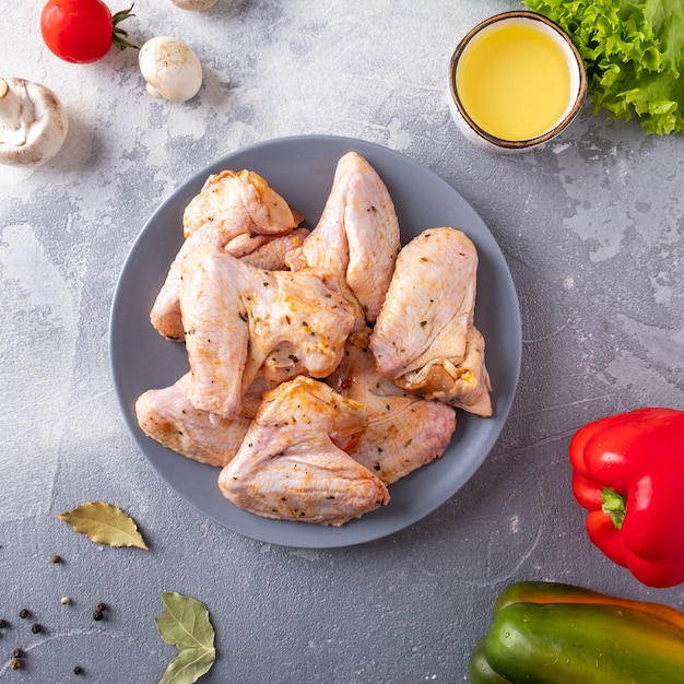 Raw marinated chicken wings on a plate.