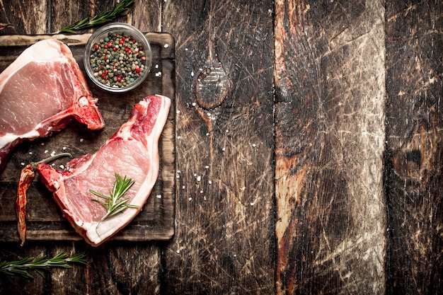 Raw meat background. Raw pork with spices . On the old wooden table.