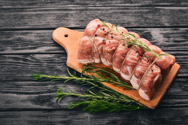 Raw meat Beef fillet with rosemary and spices on a black wooden background Top view Free space for text