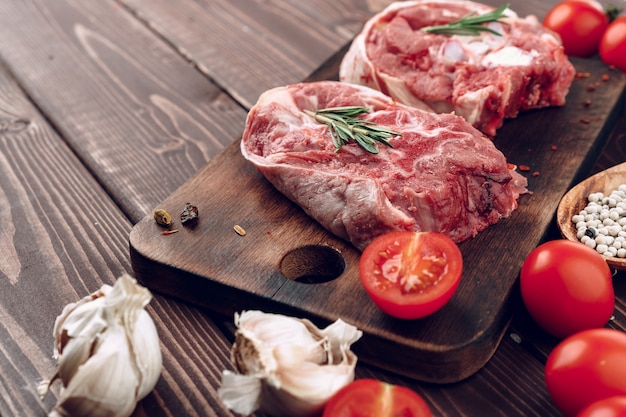 Raw meat beef shank slices on brown wooden board close up