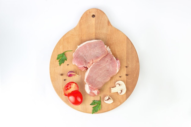 Raw meat Pieces of raw beef steaks with ingridients on cutting board Concept of food preparation