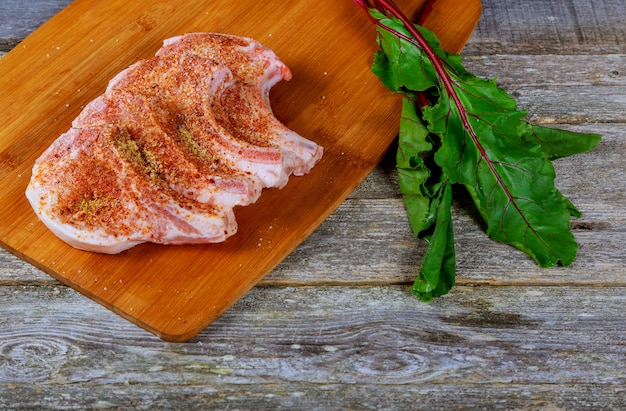 Raw meat steak on dark wooden board.